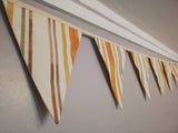 Stripy fabric bunting, mustard, yellow and shades of brown.