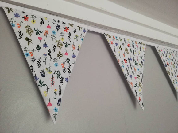 Wildflower fabric bunting. Dainty flowers and leaves on a grey or white background.